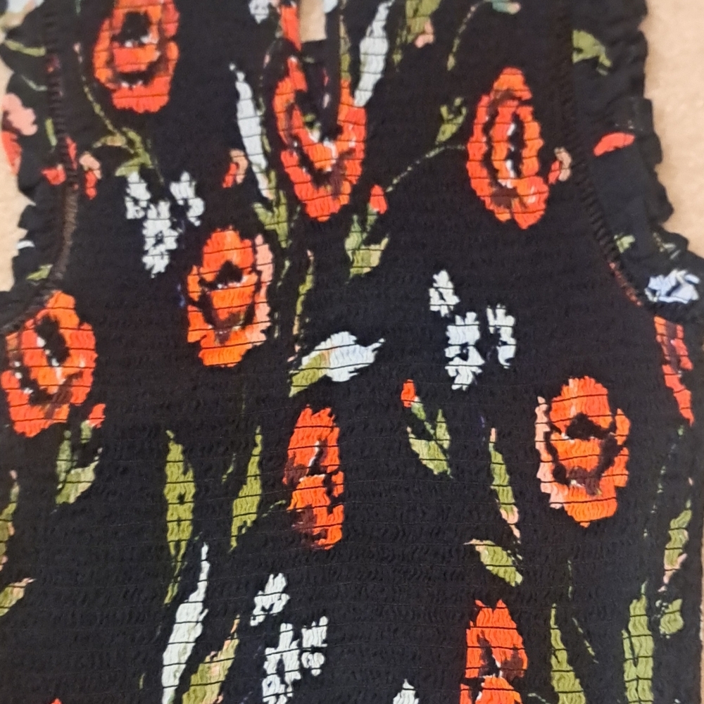 Black floral ruchet crop top with ruffled sleeveless design.
